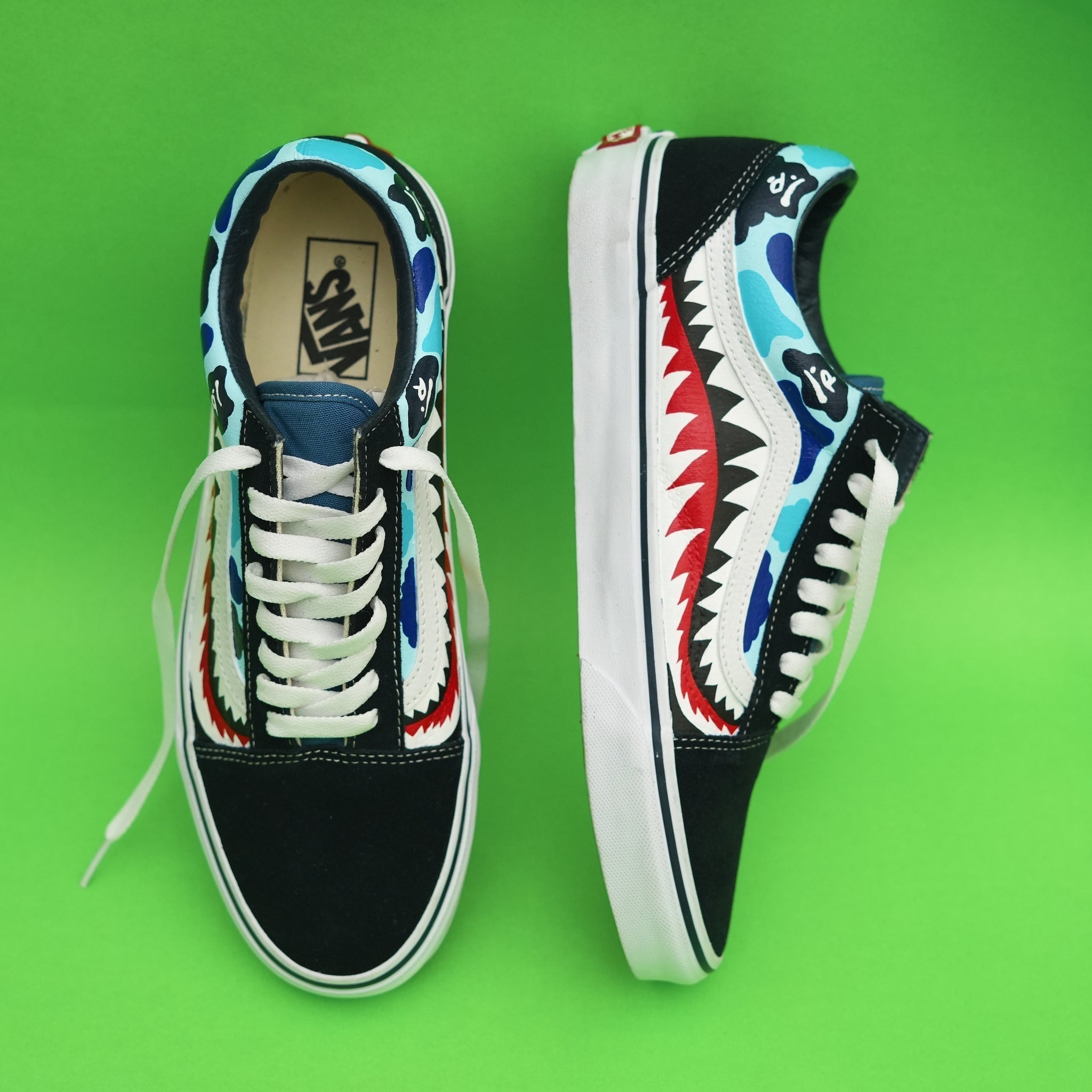 Colorful Vans Old Skool sneakers with shark and camouflage design on green background
