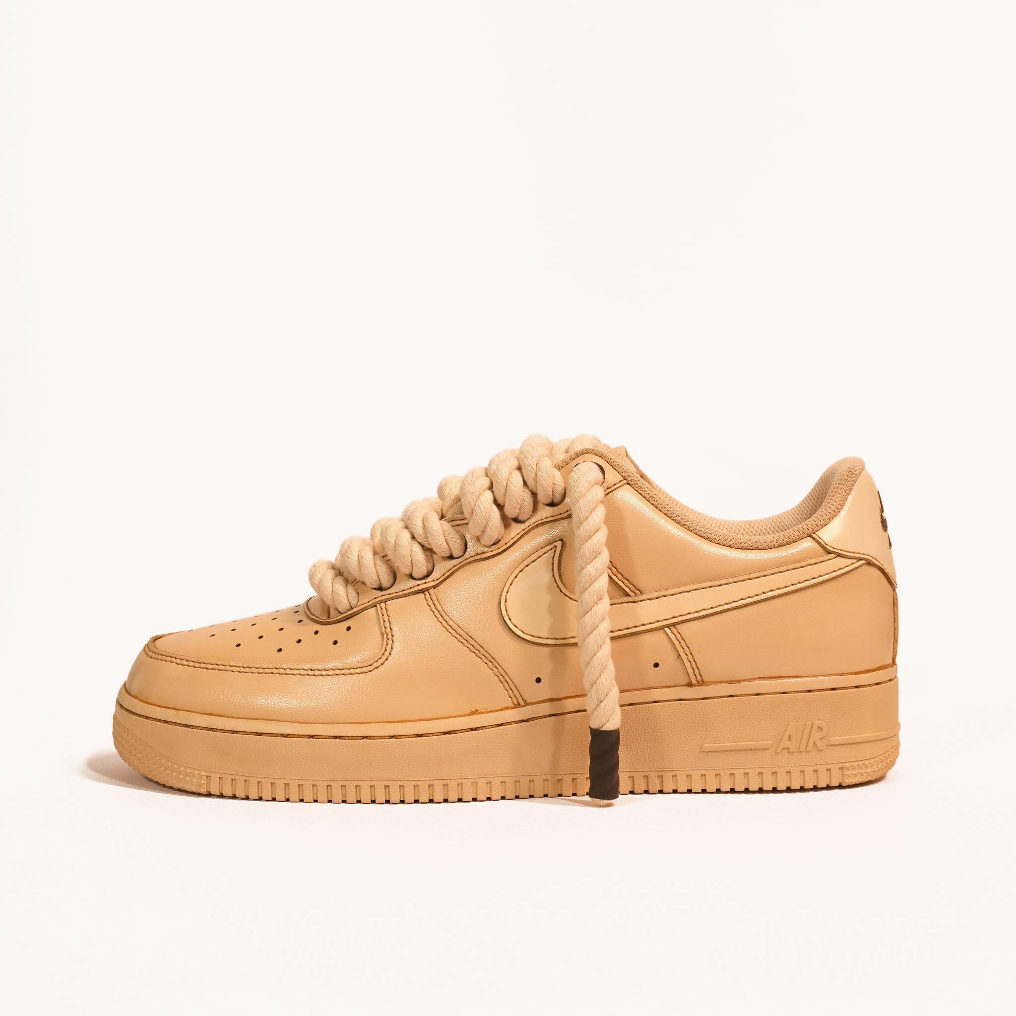 Tan streetwear sneaker with oversized rope laces, minimalist leather design, side profile view