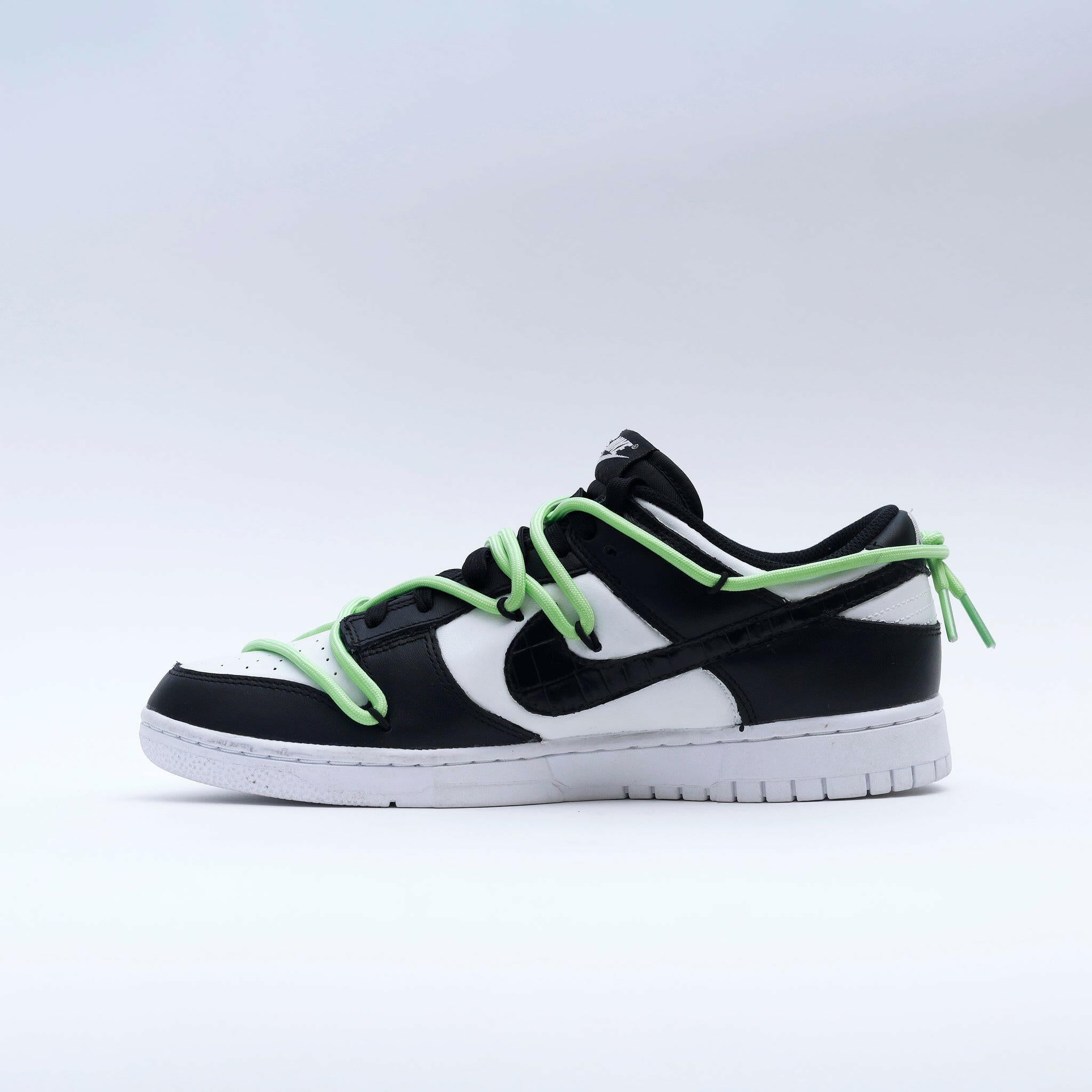 Black and white low-top sneaker with neon green laces, classic streetwear style footwear