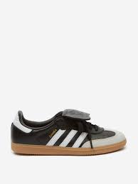 Black and white low-top sneaker with gum sole, three side stripes, and streetwear style.
