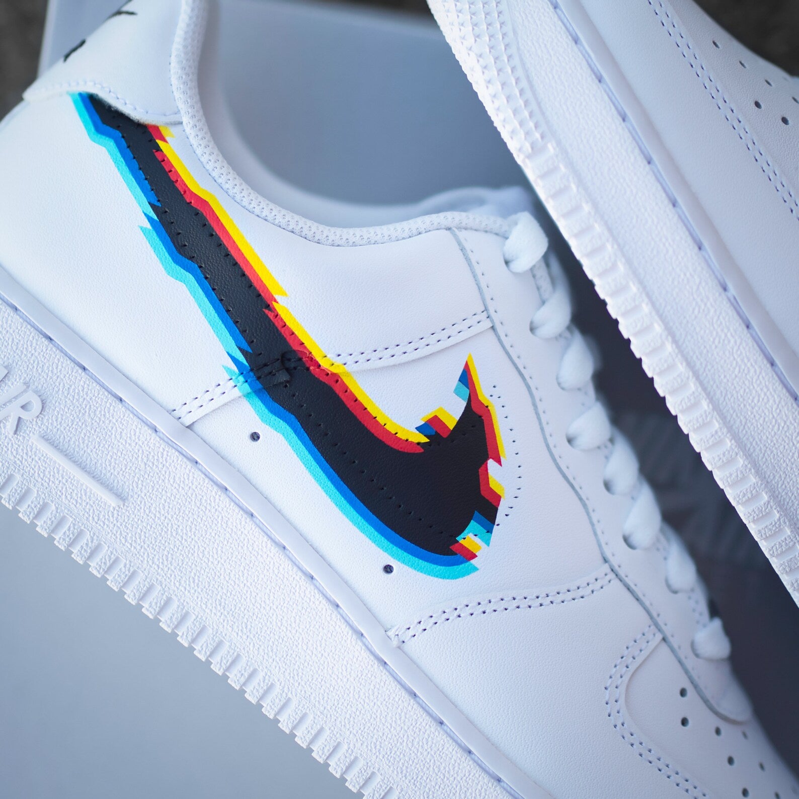 White streetwear sneaker with multicolor glitch-effect Swoosh logo design