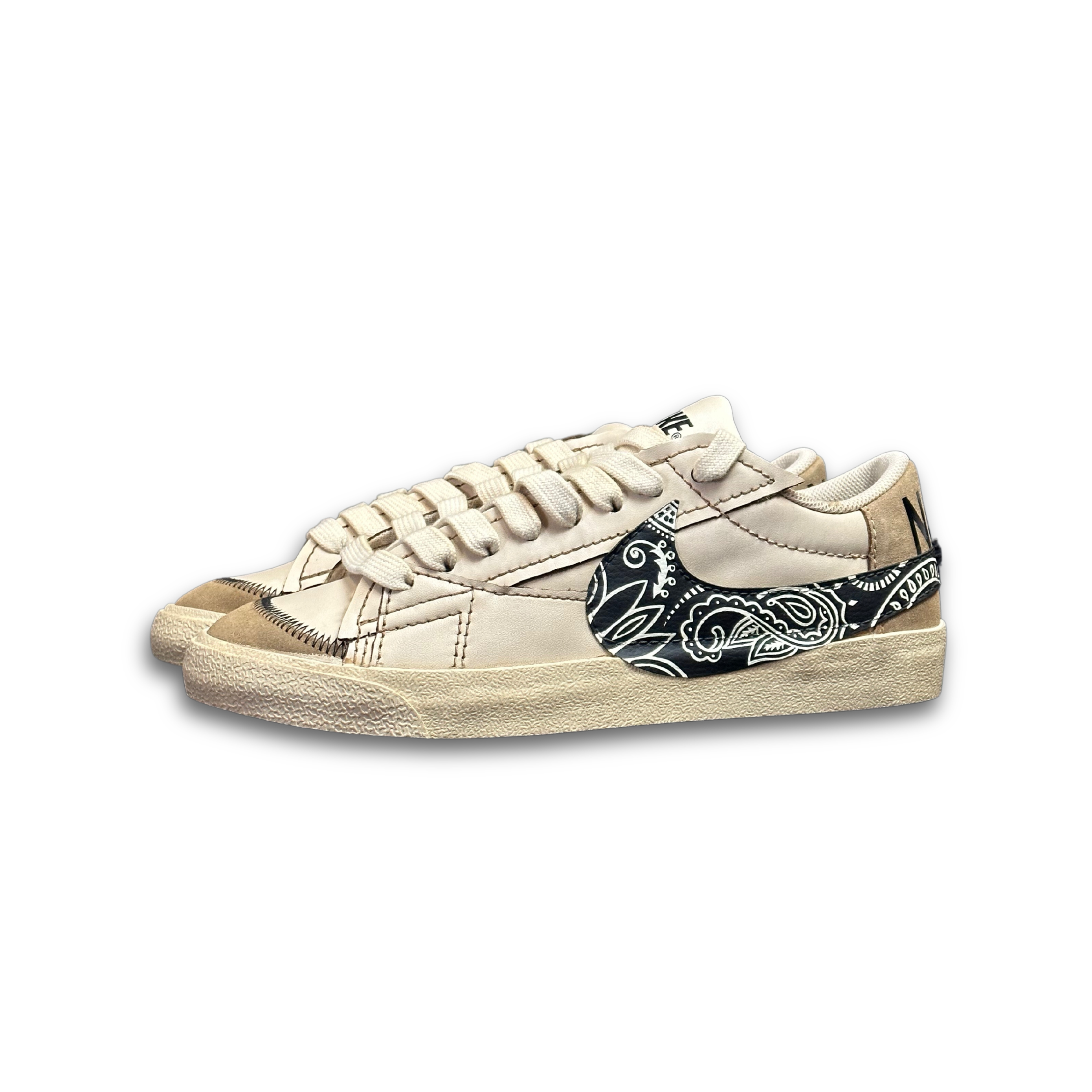 Beige streetwear sneakers with black paisley patterned swoosh and textured sole