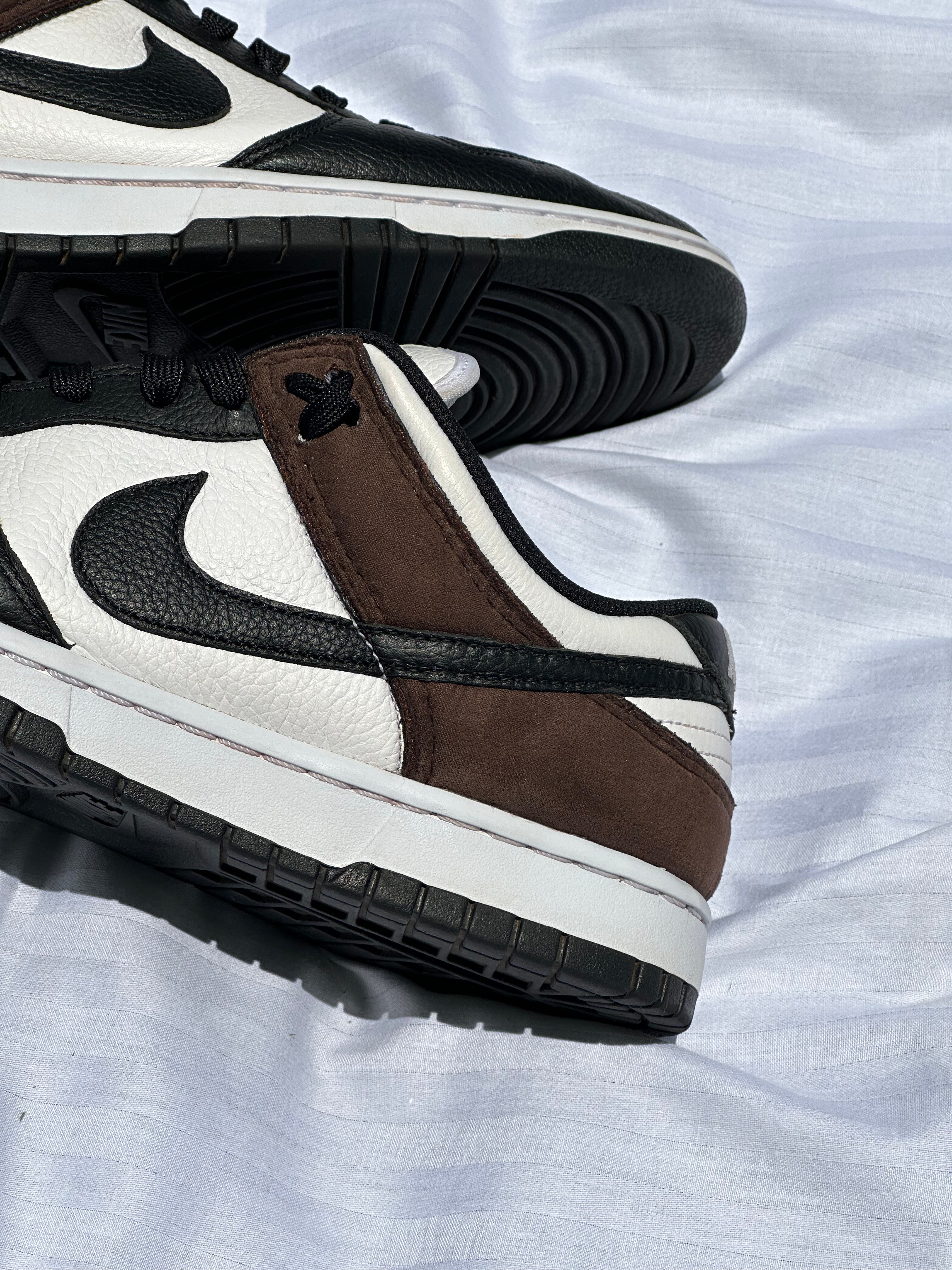 Black and white leather low-top sneakers with brown suede overlay on white fabric background