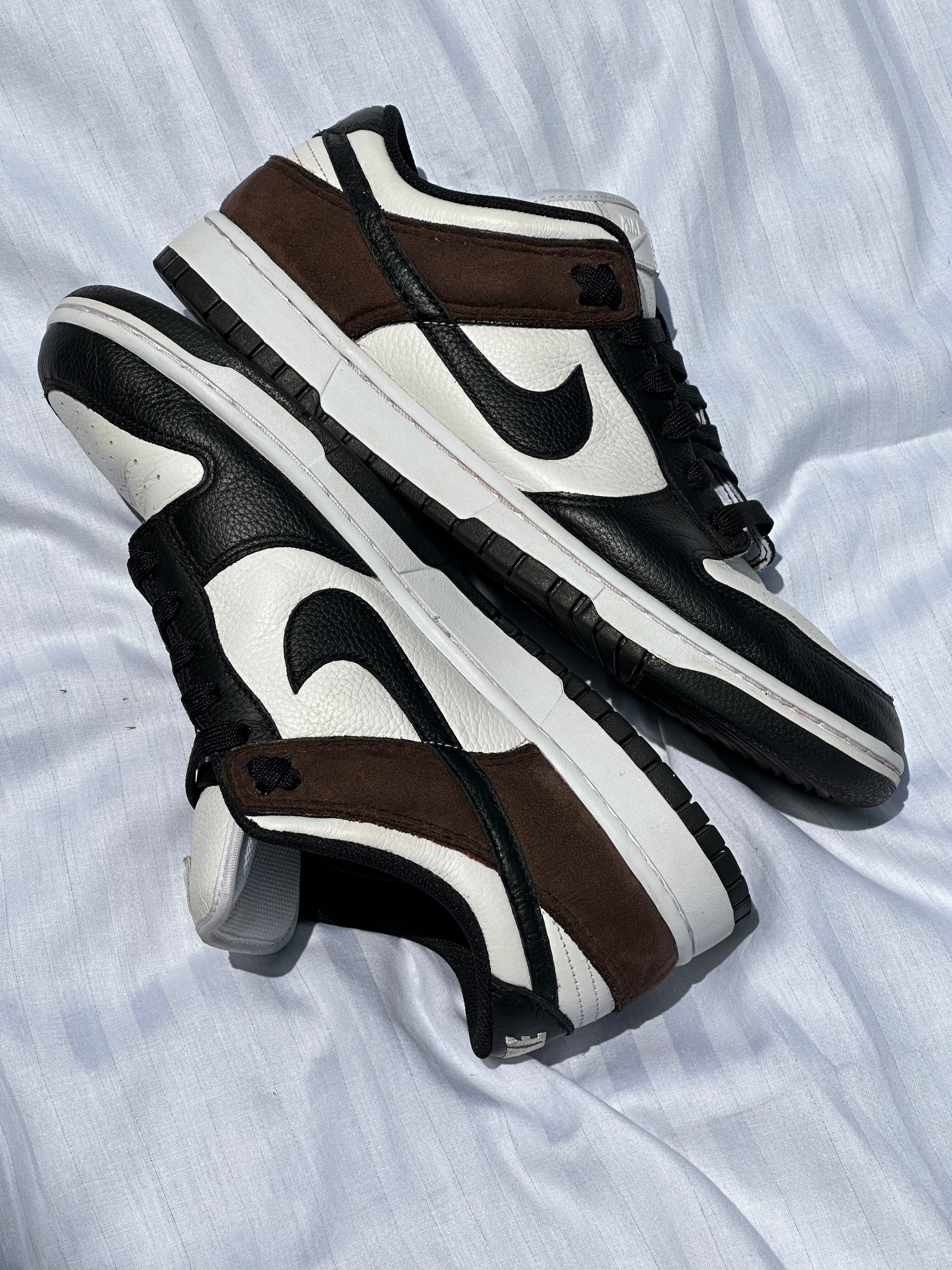 Black, white, and brown low-top sneakers with leather and suede details on white fabric background