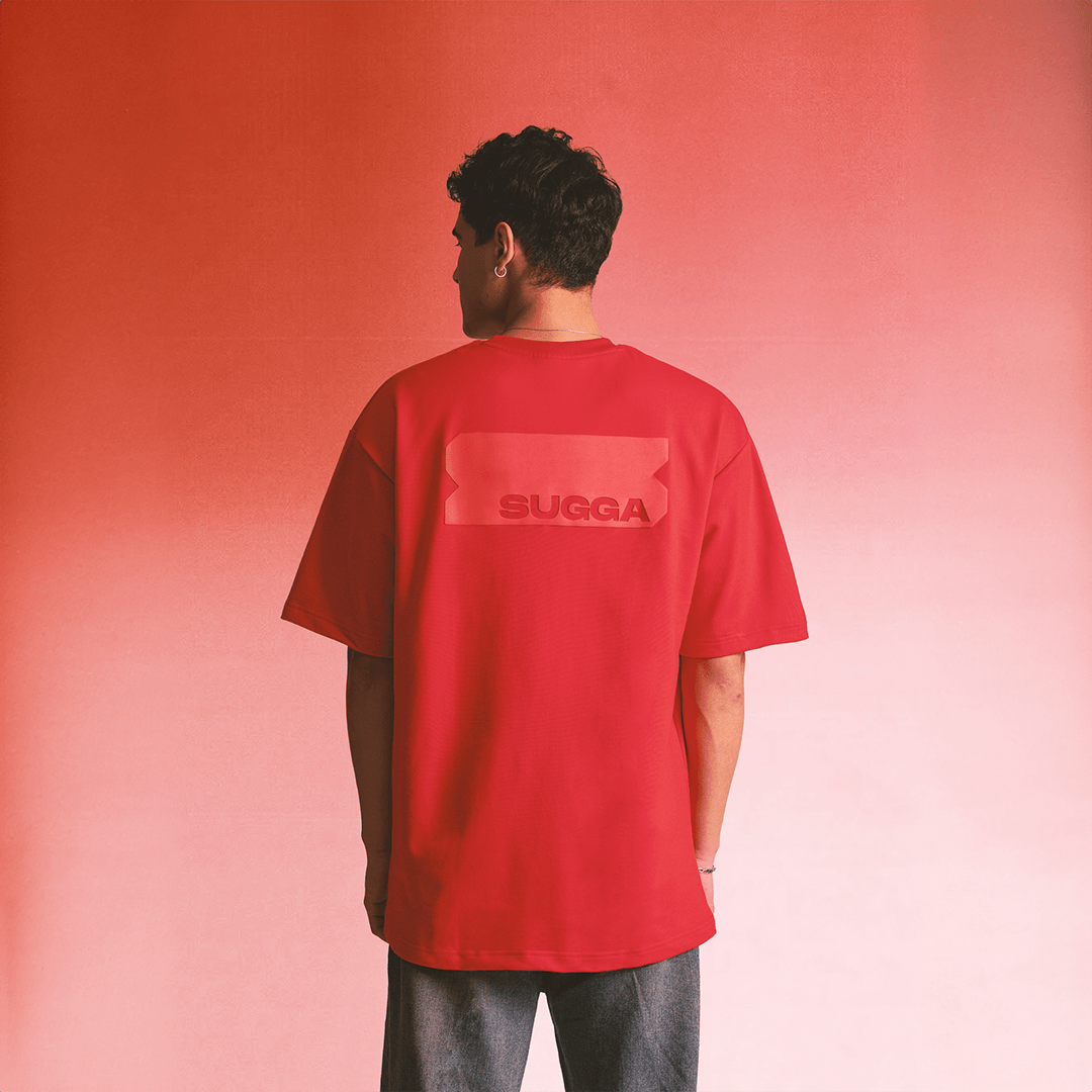 Red streetwear t-shirt with SUGGA logo on back, modeled against a red background