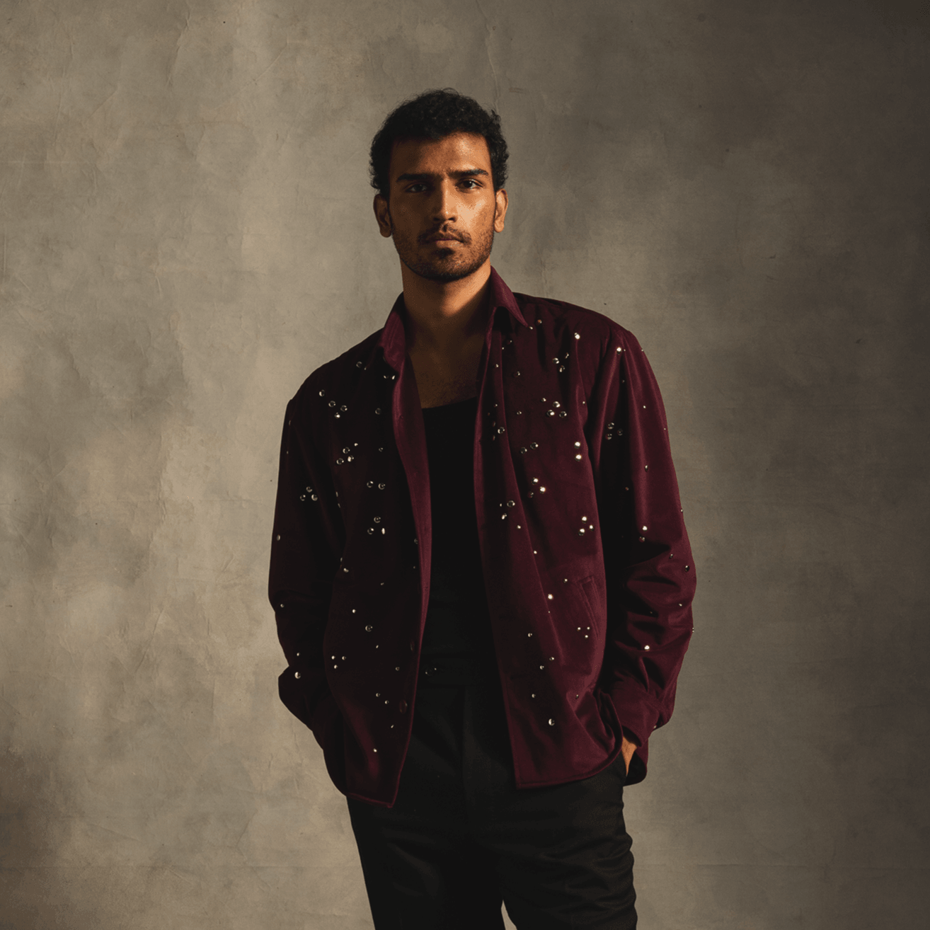Man wearing a red velvet shirt with silver studs, stylish streetwear fashion