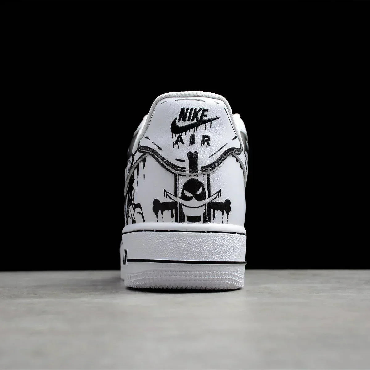 Rear view of white Nike Air sneaker with black street art graffiti design on heel