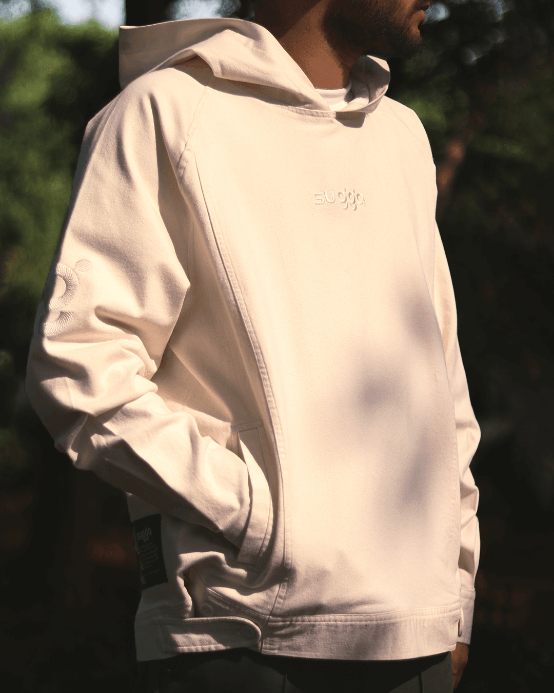 man wearing white streetwear hoodie with front pocket and subtle embroidered logo