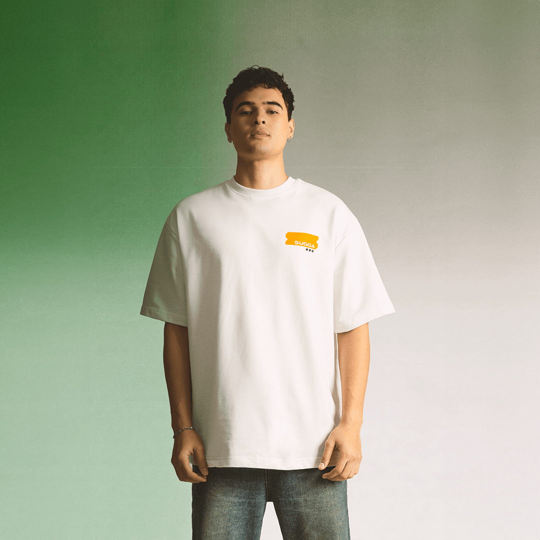 Man wearing oversized white streetwear t-shirt with small yellow graphic on chest, casual style