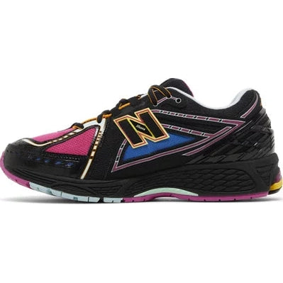 Black New Balance sneaker with gold, blue, and pink accents on a white background