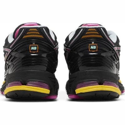 Back view of black New Balance sneakers with yellow and pink accents, streetwear style