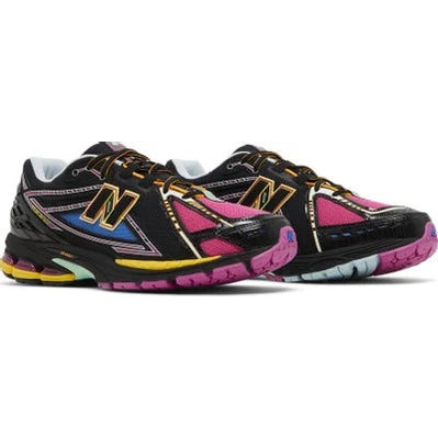 Multicolor New Balance sneakers with black, pink, yellow, and blue accents on a white background.