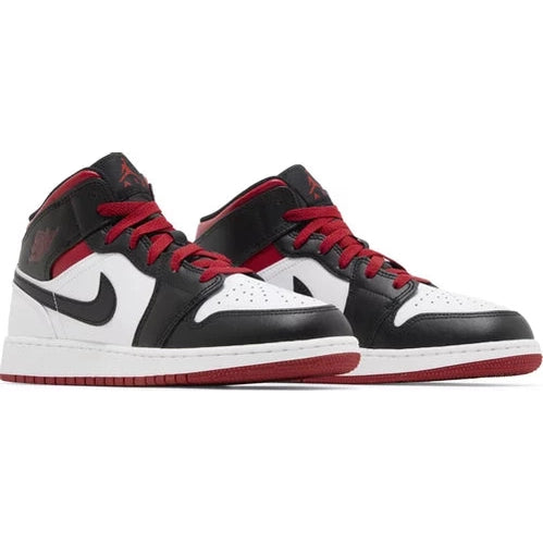 Black, white, and red mid-top sneakers with Nike swoosh and unique panelling on white background