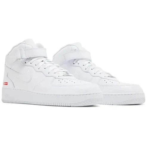 All-white high-top streetwear sneakers with ankle strap and minimal red tag detail