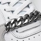 Silver chain bracelet on a white sneaker