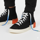 Black high-top sneakers with white - blue - green gradient shoelaces shown on a white background 