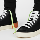 Black high top shoes and the shoelaces worn are Neon green and white gradient shoelaces on a white background