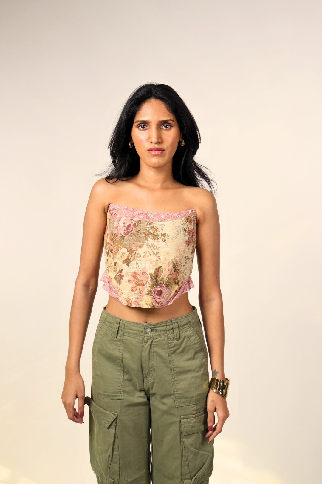 Woman in a floral crop top with lace trim and olive cargo pants, streetwear fashion