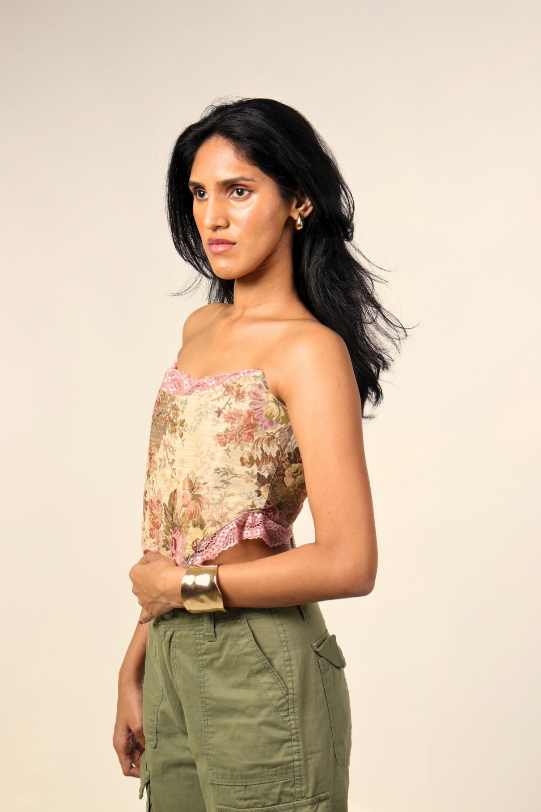 Woman in floral lace-trim bandeau top and olive cargo pants, studio fashion photo