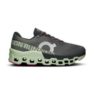 Men's On Running sneaker with black mesh upper, oversized logo, green CloudTec sole, and pink accents.