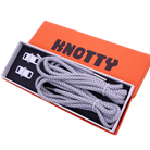 A set of reflective shoelaces and a premium metal dubrae tag with the brand name 'KNOTTY' on a orange and black label packaging.