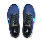 Blue On Cloudmonster sneakers with black and green laces, top view, athletic footwear
