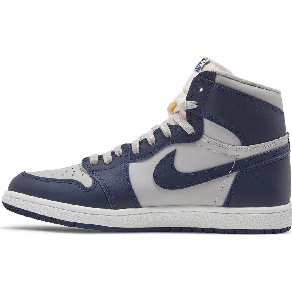 High-top sneaker with navy blue and white leather panels, white sole, and laces, side view
