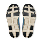 Pair of sneakers with beige and black textured outsoles, viewed from the bottom