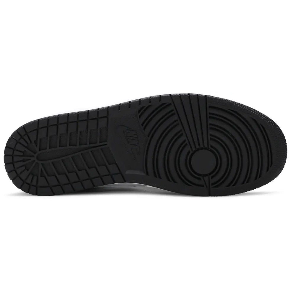 Black rubber sole of a high-top sneaker with circular and grid tread patterns
