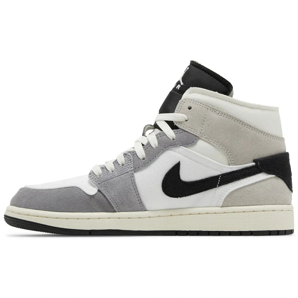 Grey, white, and black mid-top sneaker with suede overlays and black swoosh logo