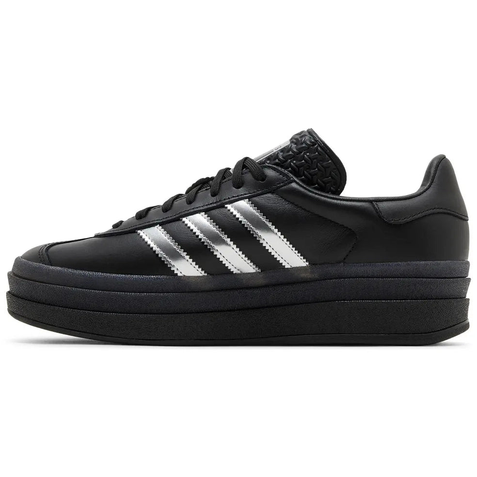 Black platform sneaker with silver stripes, chunky sole, and textured tongue, side view