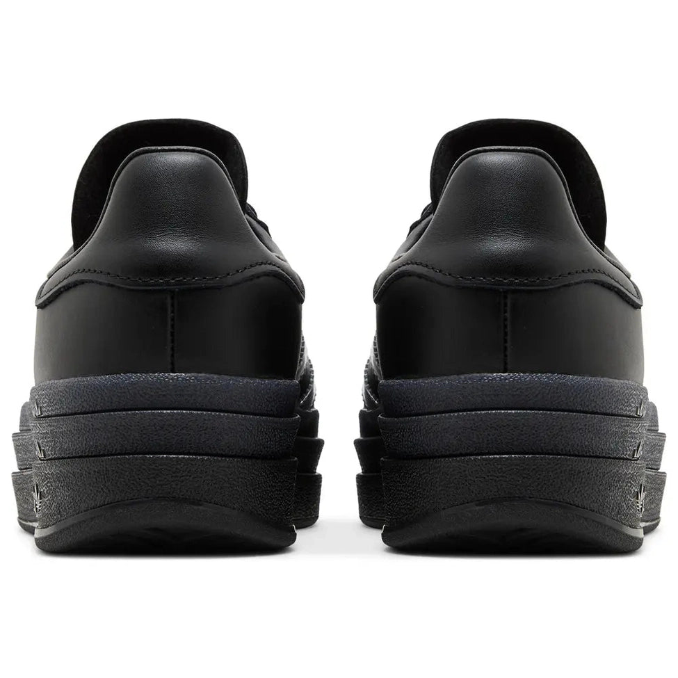 Back view of black stacked sole designer sneakers on white background