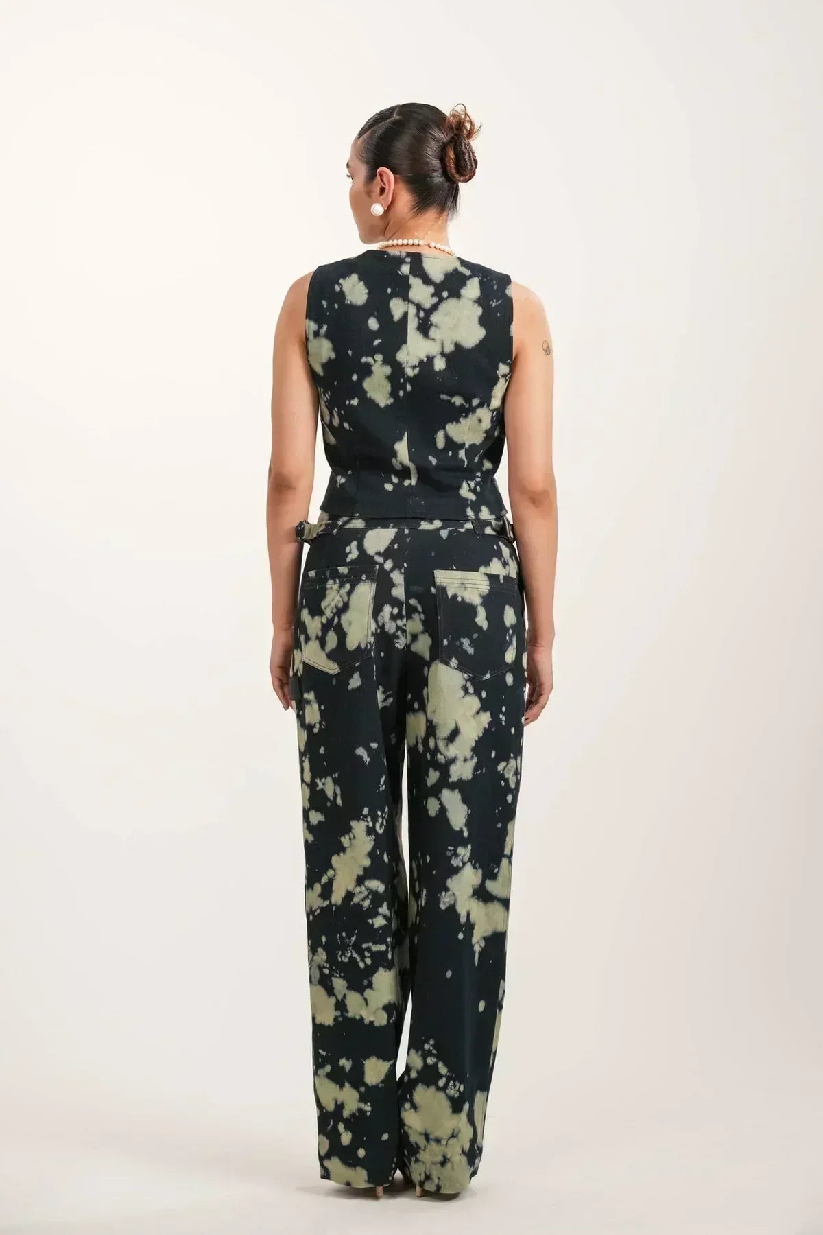 Woman wearing black tie-dye sleeveless top and matching wide-leg pants from rear
