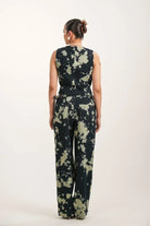 Woman wearing black tie-dye sleeveless top and matching wide-leg pants from rear