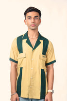 Man modeling a short sleeve, yellow and green colorblock bowling shirt with front pockets