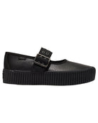 Black crepe sole shoe with a buckle on a light gray background