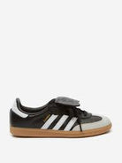 Black and white low-top sneaker with gum sole, three side stripes, and streetwear style.