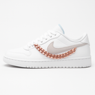 White sneaker with a gold chain detail on a white background