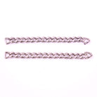 Two silver Cuban link sneaker chains laid out on a white surface.