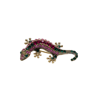 Gold-tone gecko sneaker charm with pink and green crystal detailing on black background