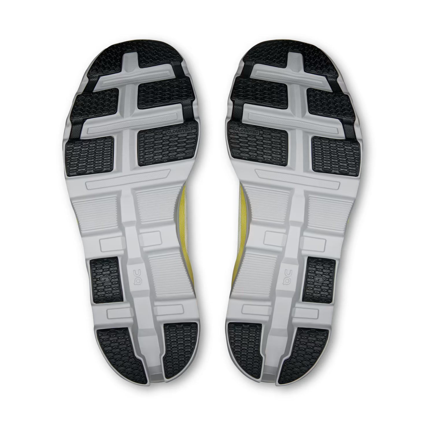 Close-up of black and white sneaker soles with textured grip and yellow detail, streetwear footwear